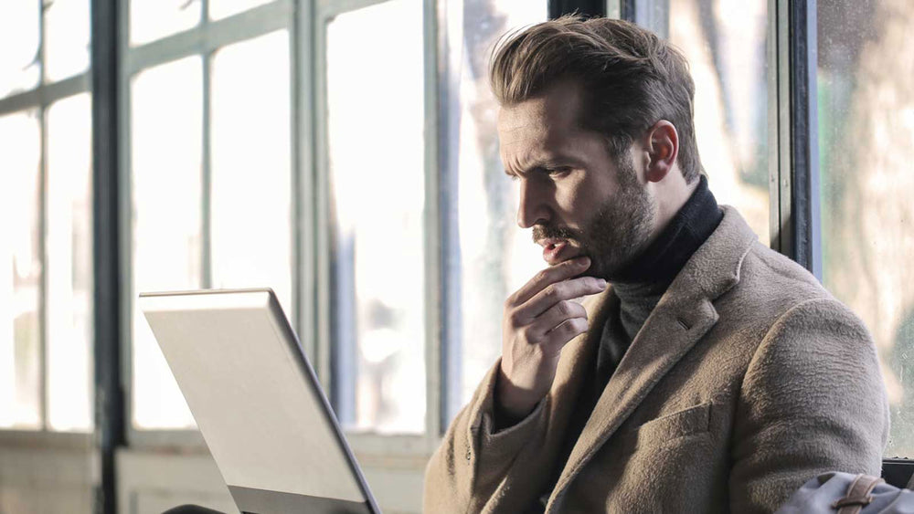 Man searching the internet on his laptop for Heartburn relief