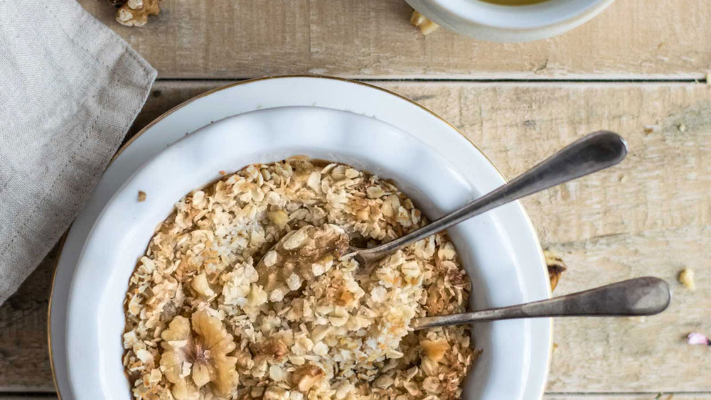 Bowl of oatmeal on a wooden table viewed from the top down